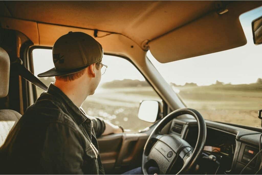 Young driver behind the wheel of a vehicle at sunset