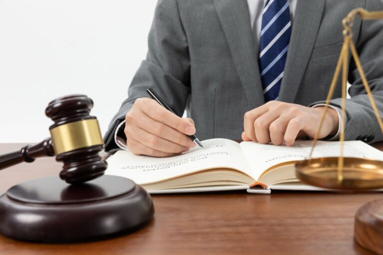 A legal professional in a gray suit writing notes