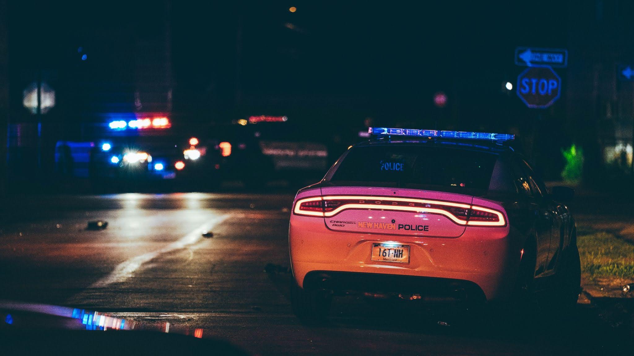 Police cars at a nighttime DWI stop with emergency lights flashing on a Texas road